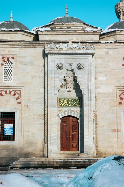 the building has two large doors and arched windows