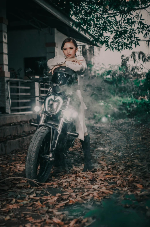 a woman in black and white standing next to a motorcycle