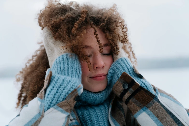 a woman covering her face and holding a glove