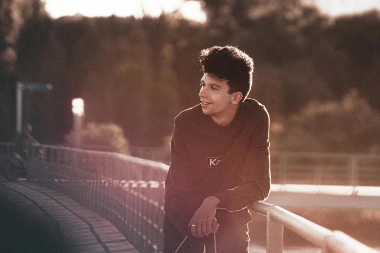 a man wearing sweatpants and a sweatshirt stands in front of a train