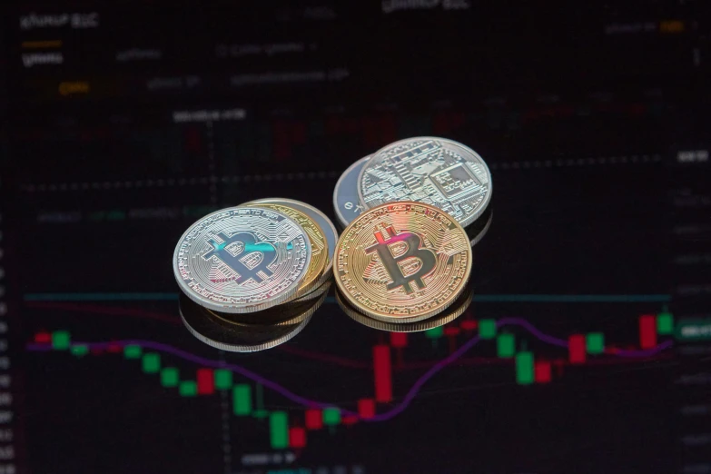 three bitcoins are shown next to a stock chart