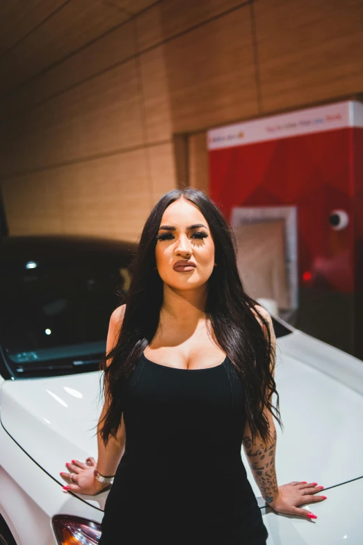 a woman is posing next to a car
