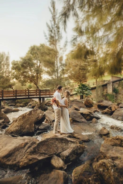 a bride and groom emcing near a waterfall