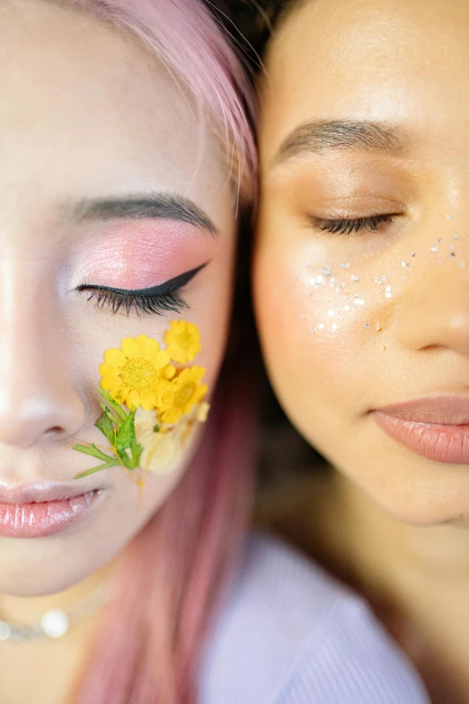 two woman posing for a camera with a flower in the eyes