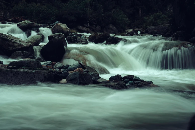 the water is rushing down the rocks by the stream