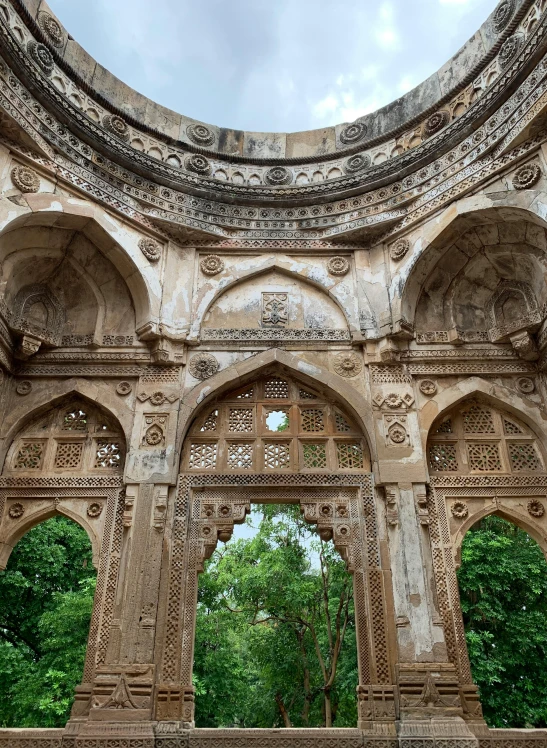 an arch with statues, and trees in the background