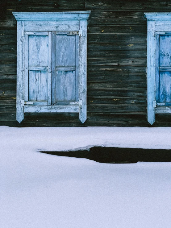 two white wooden windows covered in snow