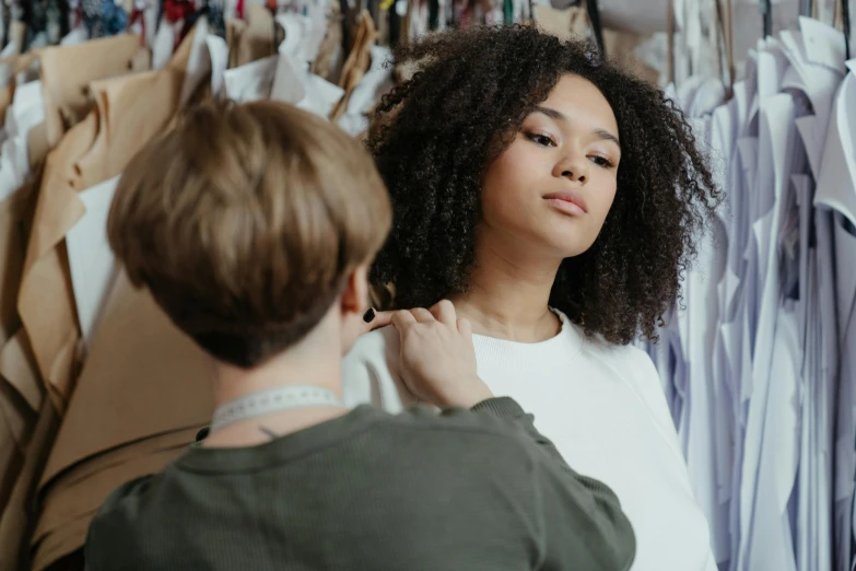 the man is trying on his hair and his girlfriend is looking at him