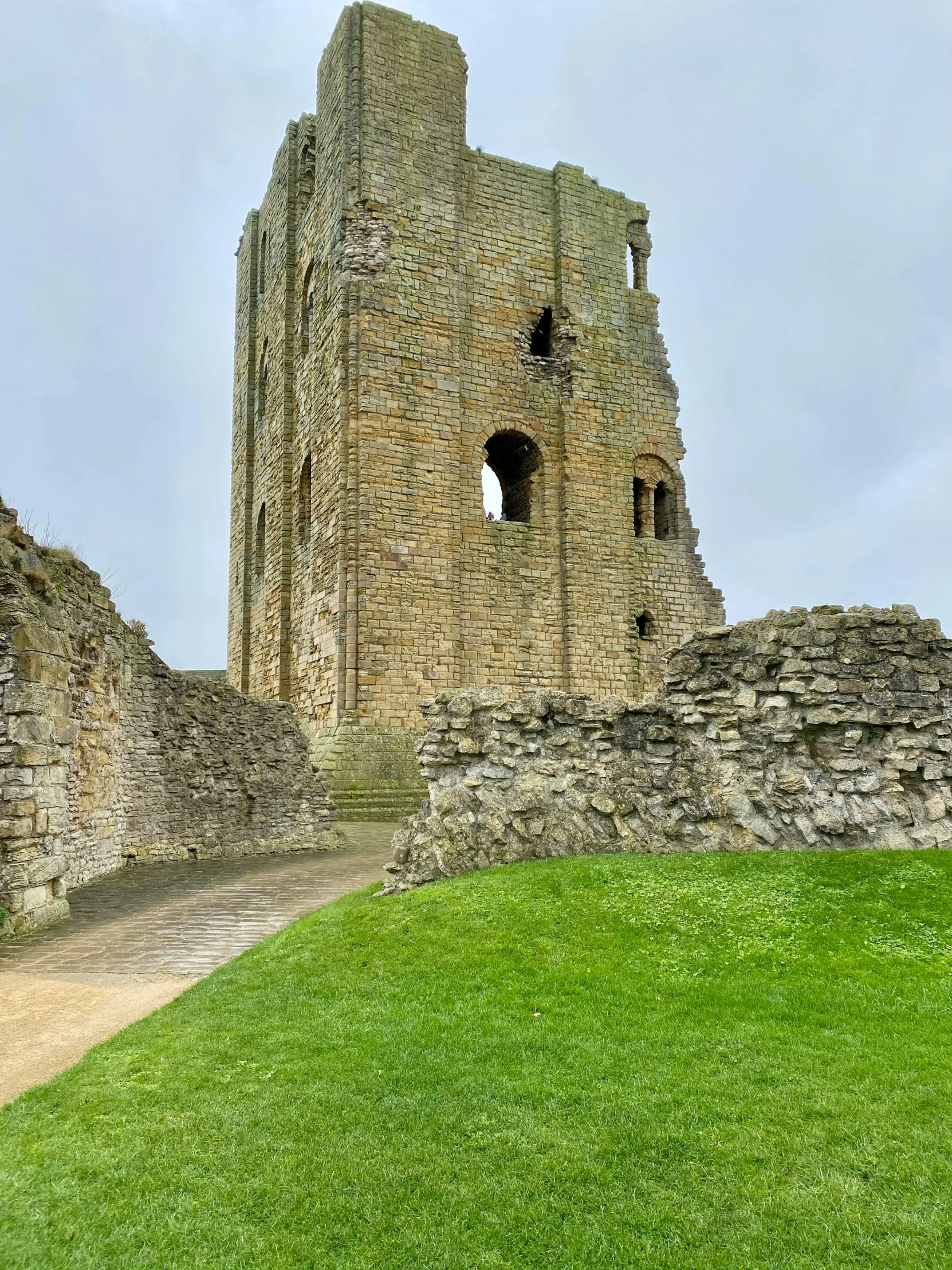 a green grass field sitting next to a stone structure