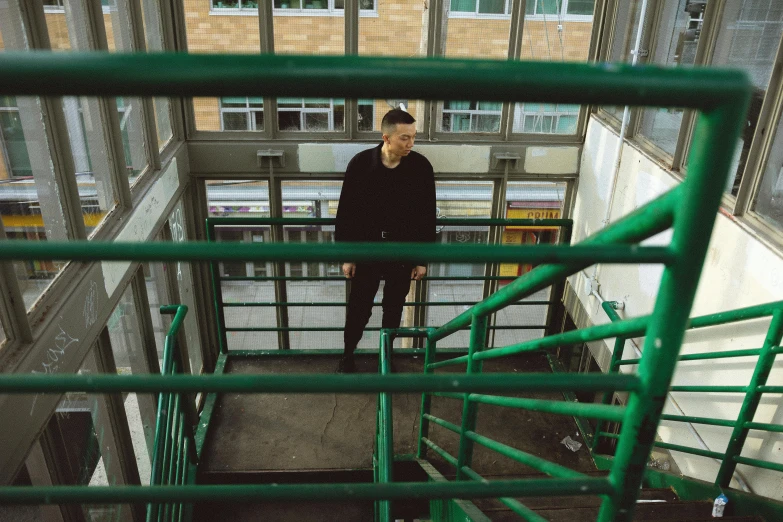 a young man is standing on a green staircase