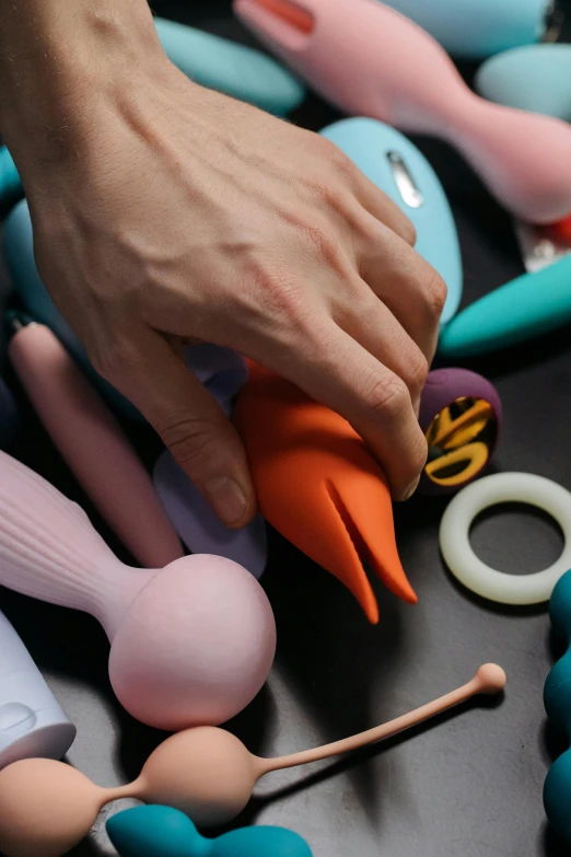 someone holding some very colorful items near some rubber toys