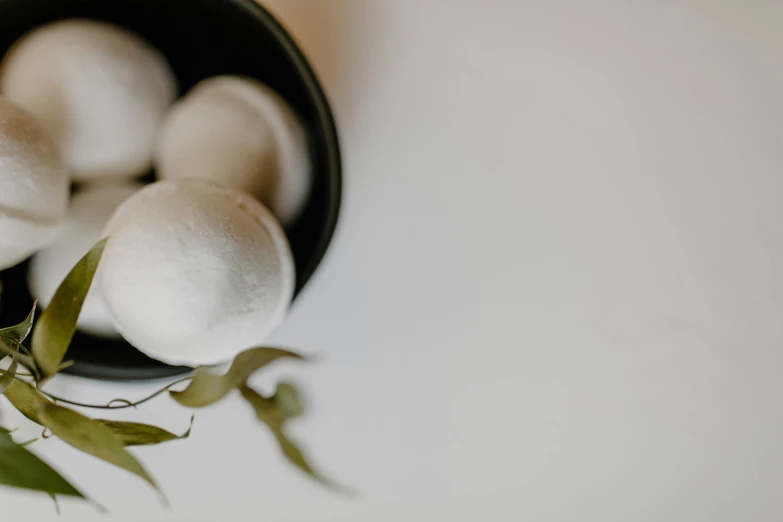 several balls of white stuff in a black bowl