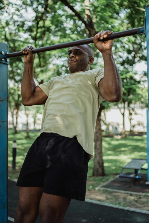 a man is standing on the bars in a park