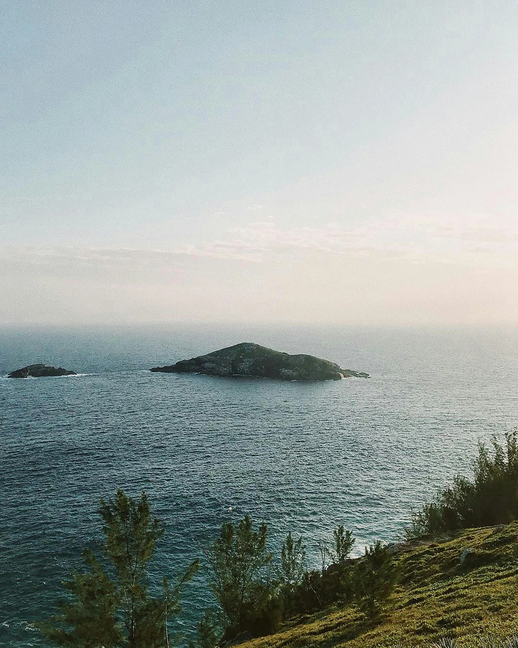 the ocean with two small islands on a hill