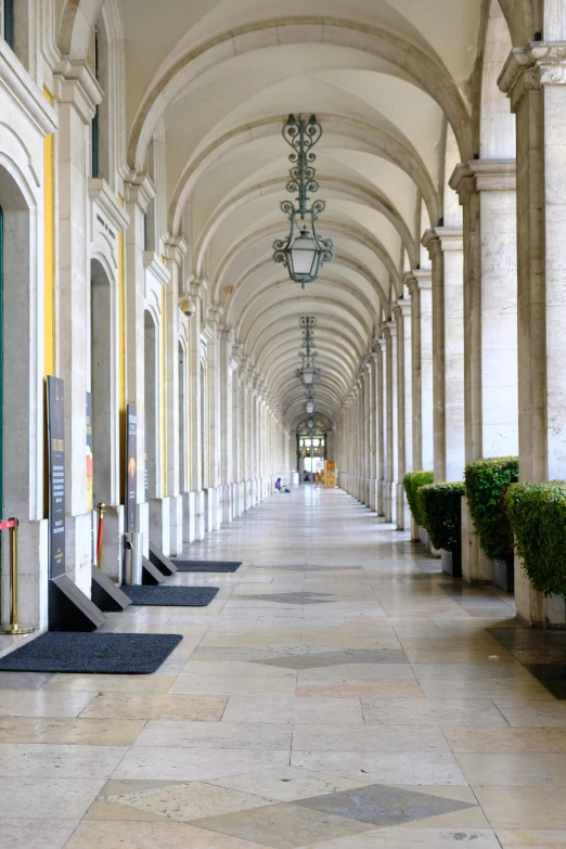 there is a long walkway with columns at the end