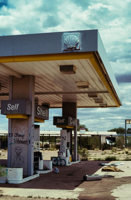 a fuel station in a deserted area has some signs attached