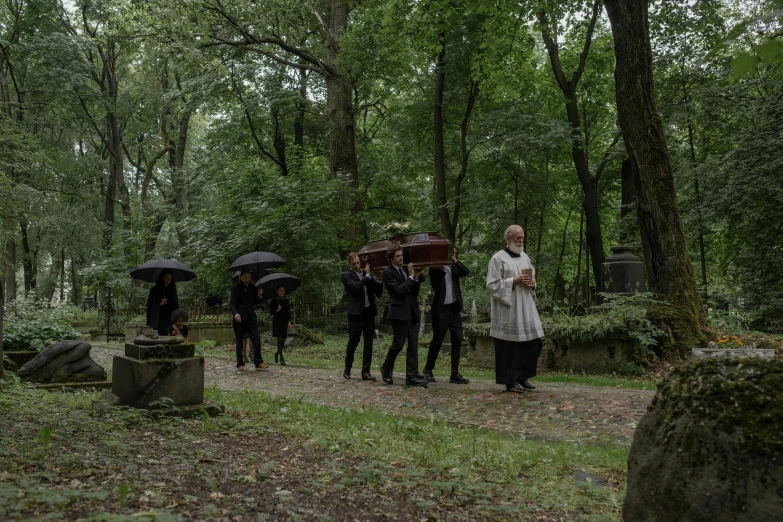 group of people walking in a forest with umbrellas