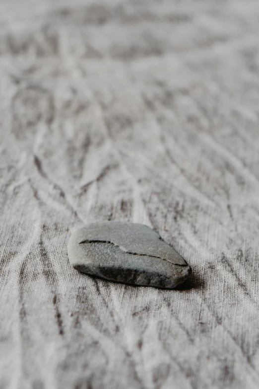 a black rock sits on the bed in this image