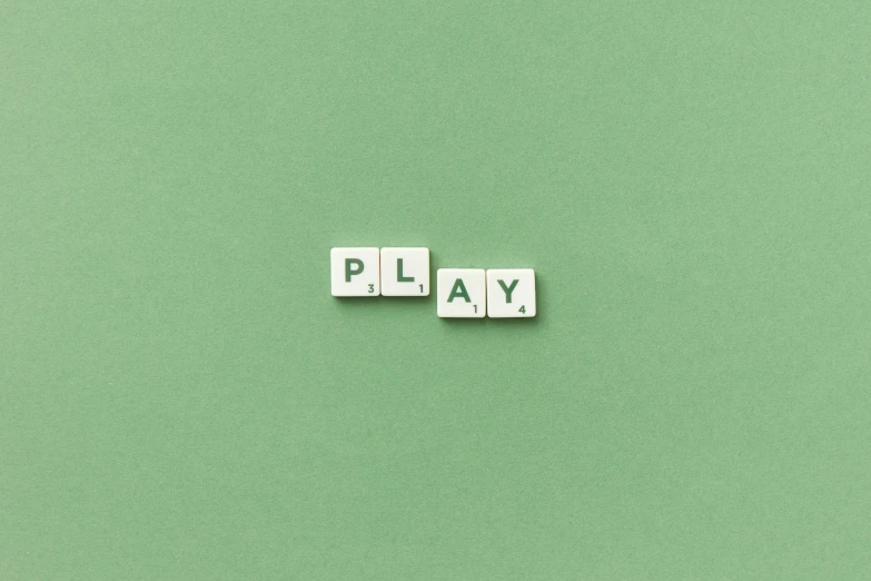 wooden blocks spelling play on a green background