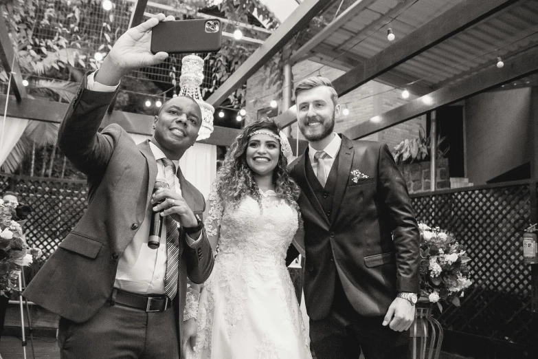 three people are taking a selfie in a wedding po