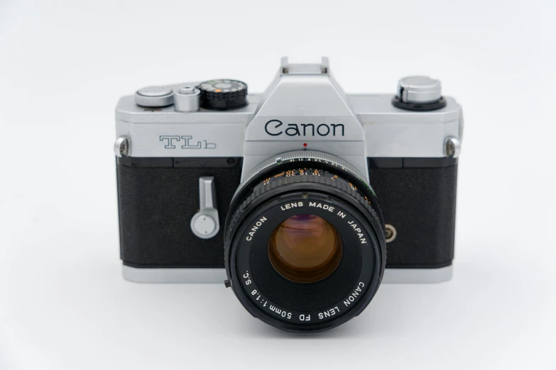 an old fashioned camera sitting on top of a white table