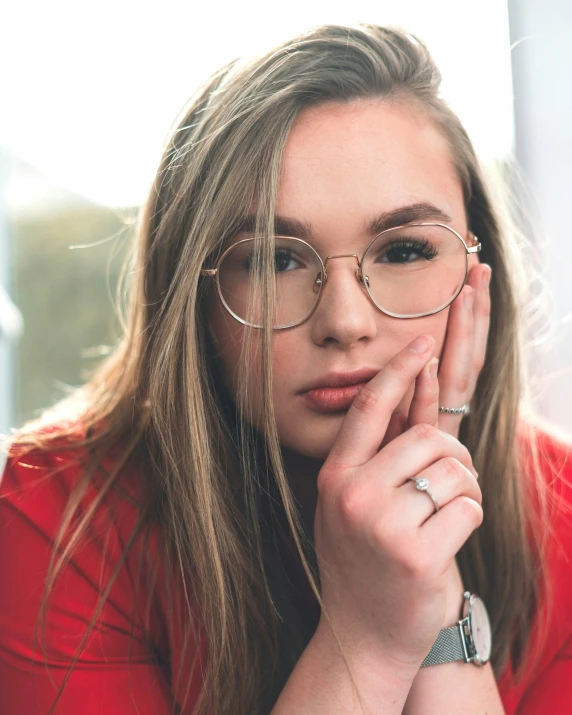 an attractive woman wearing glasses and looking to her left