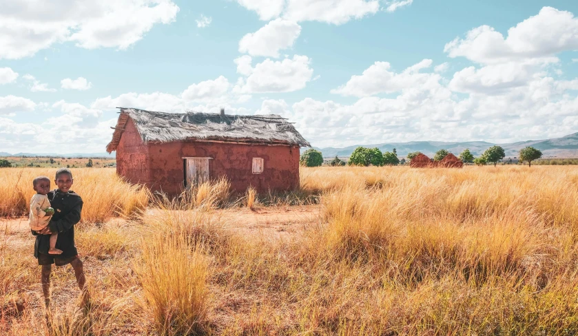 two people standing on the side of the road by an abandoned building