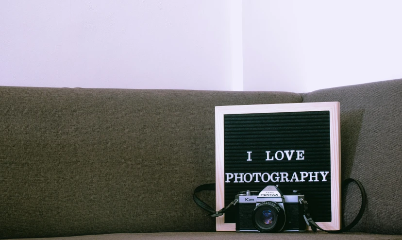 a camera sitting on a sofa with the words i love pography