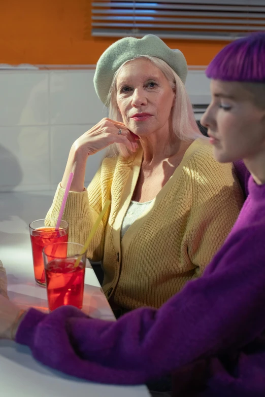 a blonde woman is using her cell phone while sitting with another women