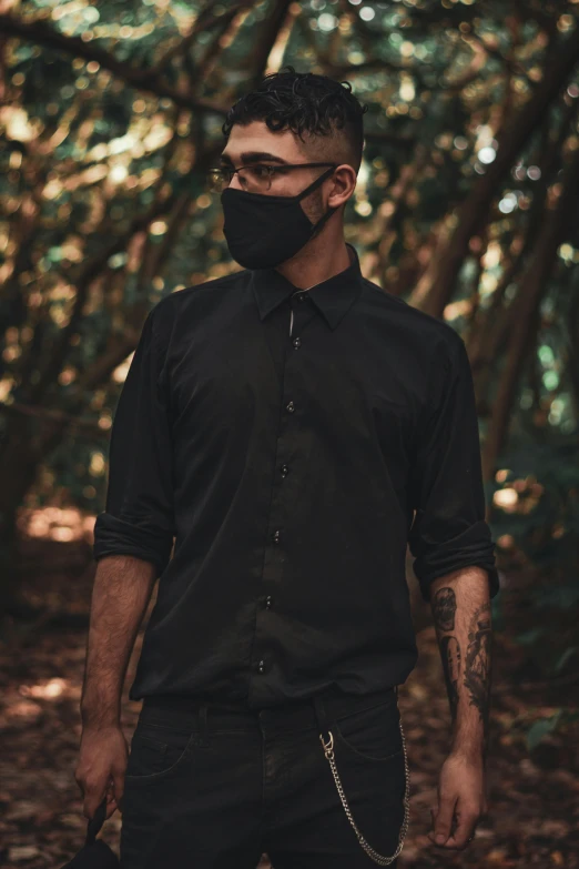 a man with black clothes and a face mask