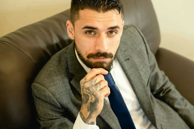 a close up of a man in a suit with tattoos