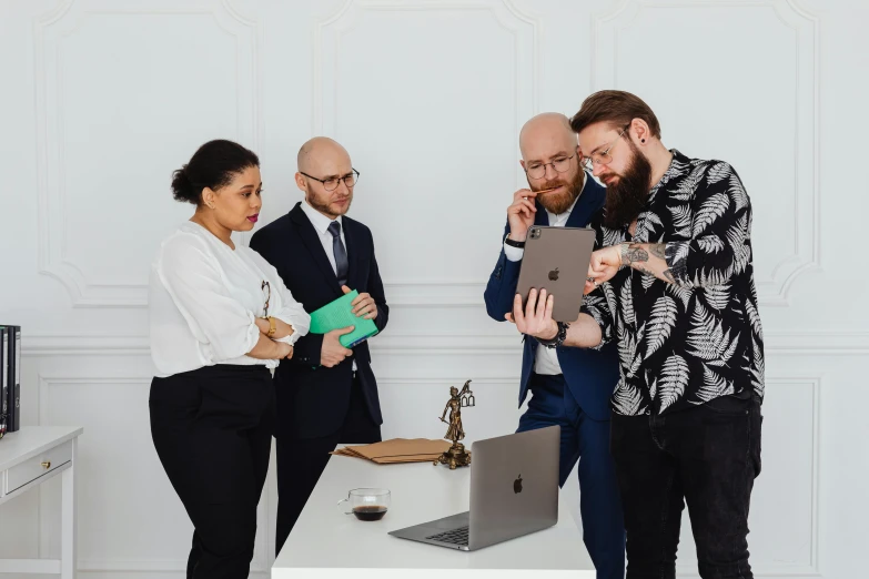 three people standing around looking at a computer