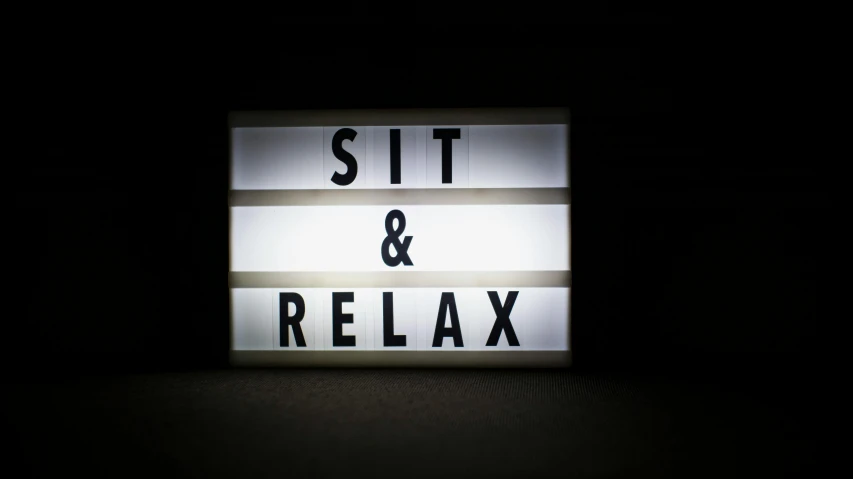 a lighted sign on a black table with white stripes