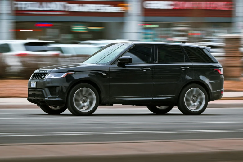 a range rover on the road near a city street