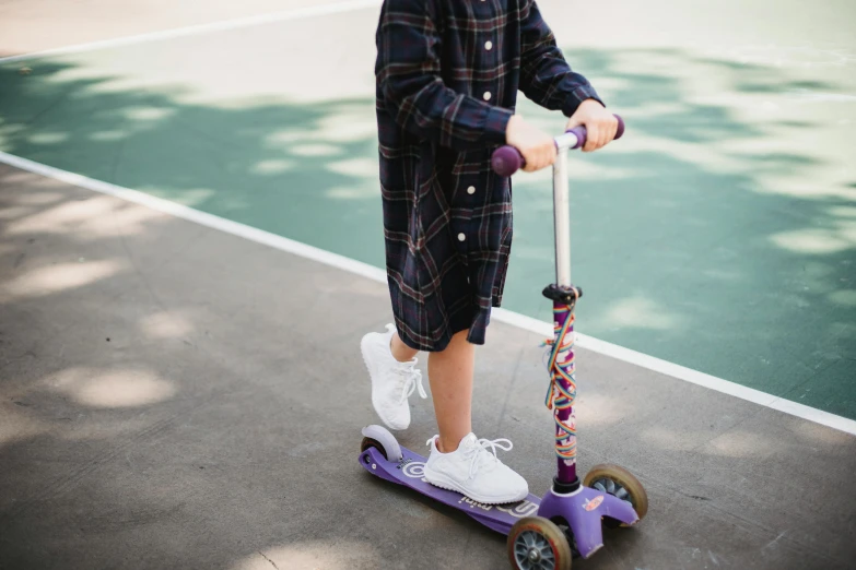 a  in blue shirt and cap on a purple scooter