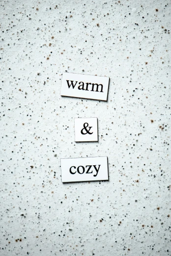 two stickers that read warm and cozy on a wall