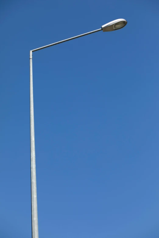 two light fixtures on pole against clear blue sky
