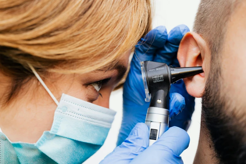 a woman getting an ear procedure for a male