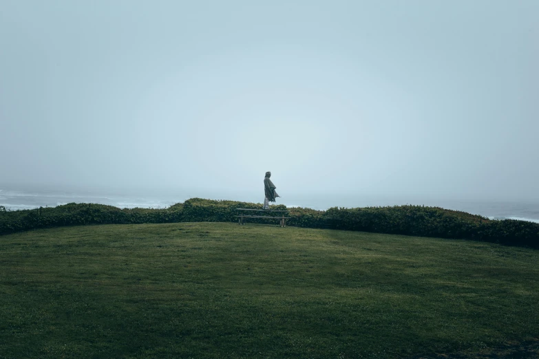 a bench and man looking out at the ocean