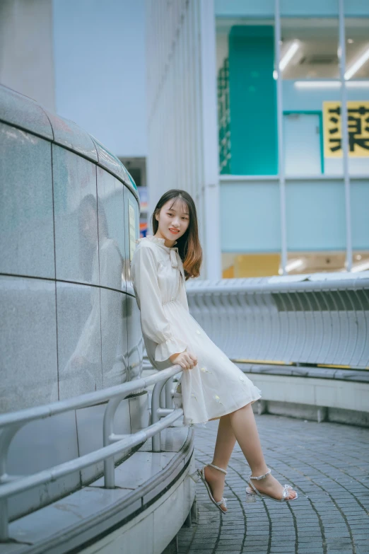 a woman poses near a wall on the street