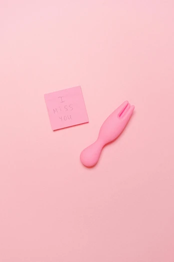a pink toothbrush with a paper with the word go is laying next to it