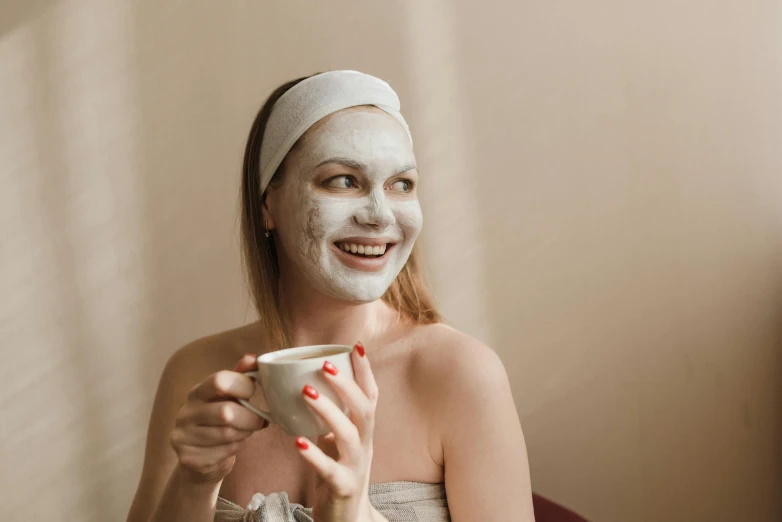 a beautiful young woman in a towel with facial mask on