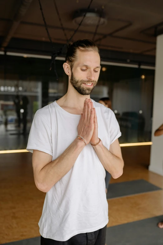 a man standing in a room with his hands together