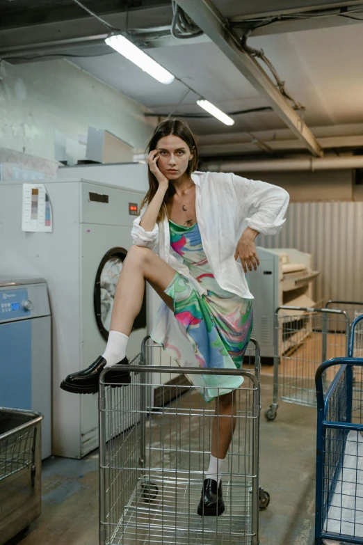 a woman sitting on top of a metal rack next to a machine