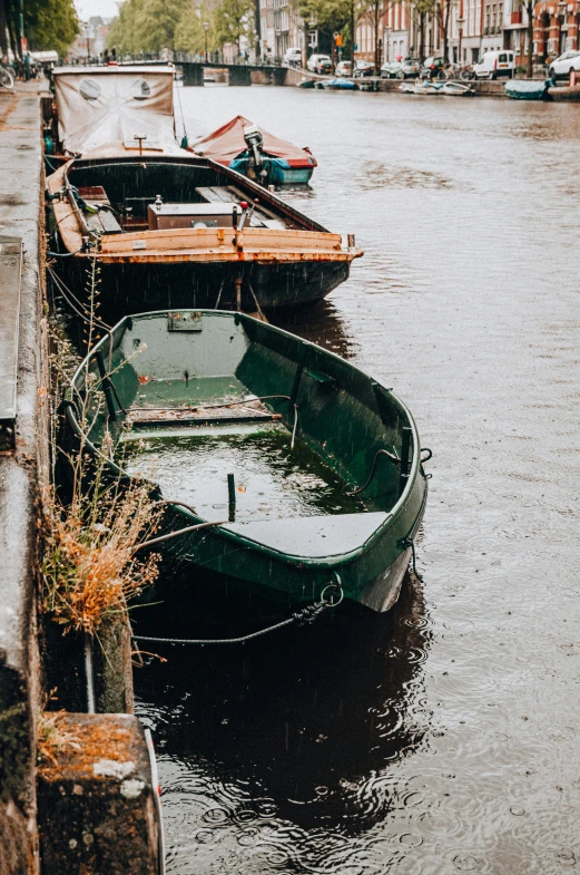 two green boats tied up to a dock