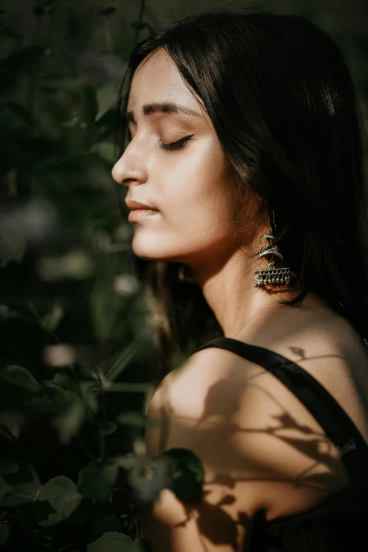 a beautiful woman posing by some leaves