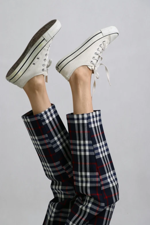 a woman in a plaid skirt standing up