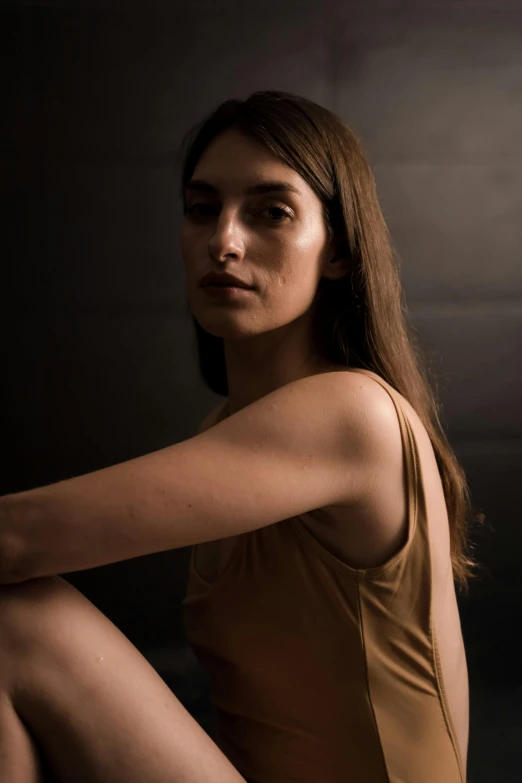 a woman sits on the floor while posing for the camera