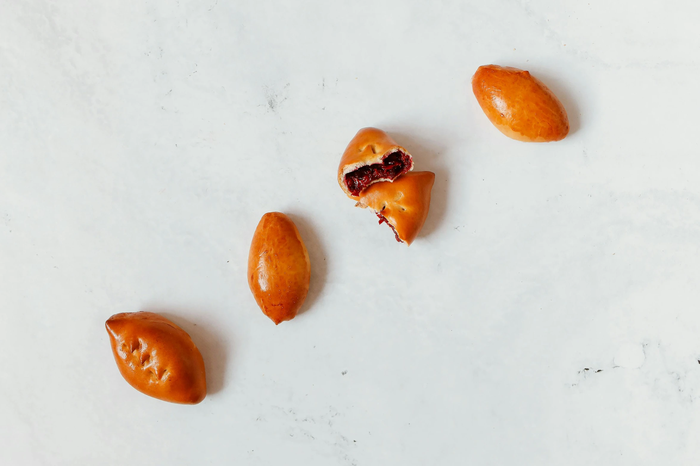 four small donuts are being peeled on a table