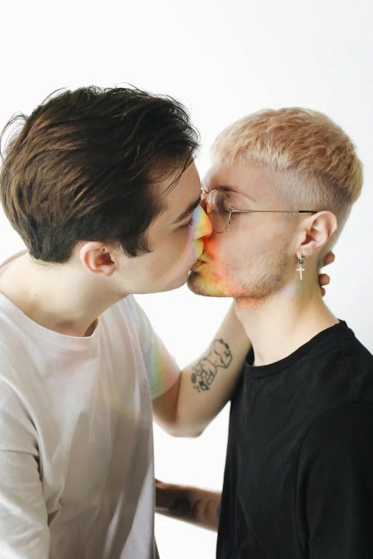 two young men posing for a picture while one kisses the other